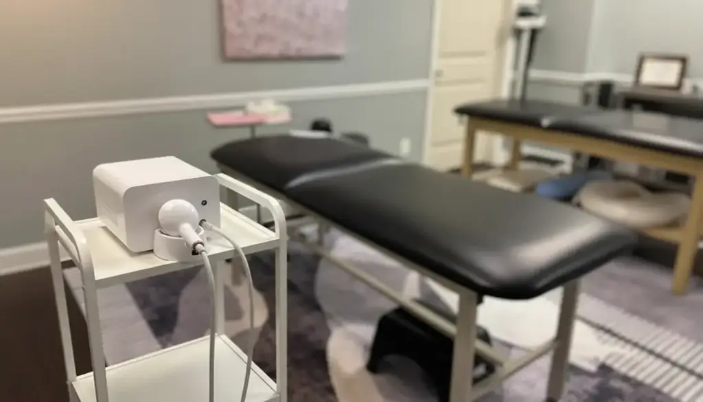 A compact radiofrequency skin-tightening console on a cart beside a treatment table